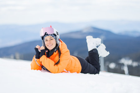 Skier girl posing laying on the snow.の写真素材