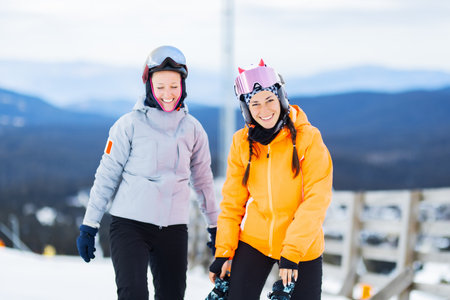 Two beautiful ski girls posing outdoors. Skier friends having fun.の写真素材