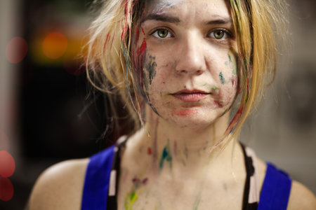 Portrait of a female artist. Girl with clumsy clorful painted face.の写真素材