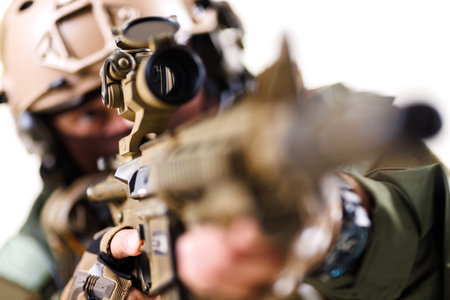 Focused tactical soldier aiming rifle with precision in combat gearの写真素材