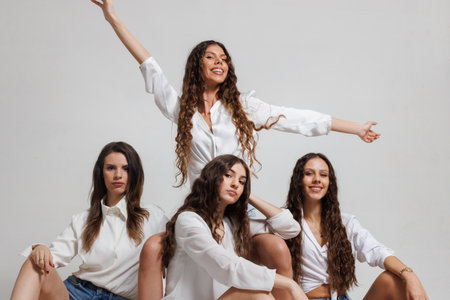 Group of four young women posing together in casual outfits showcasing friendship and unity