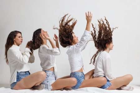 Young women in a dynamic pose with hair flowing in motion wearing casual contemporary outfits