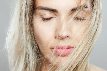 Beautiful girl fashion portrait with windy hair. Looking at camera.の写真素材