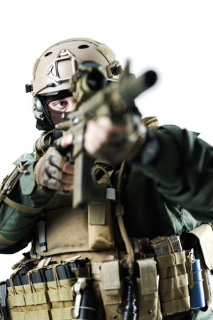 Modern soldier in tactical gear aims while keeping eye contact with precision and warinessの写真素材