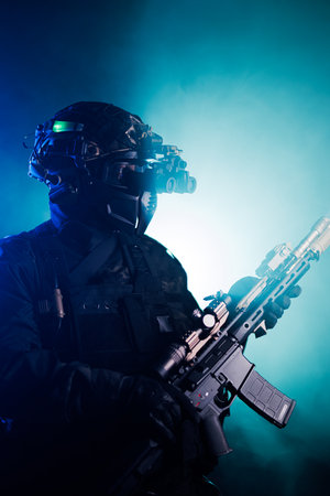 Special forces operative equipped with weapon and night vision in dramatic lightingの写真素材