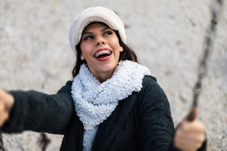 Smiling Woman Outside in Winter Wearing a Warm Hat and Scarf Close-Upの写真素材