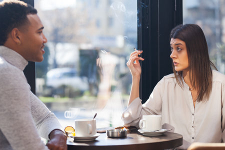 Friends in a restaurant talking smiling. Business colleagues having a meeting after work or during coffee break at a cafe bar.の写真素材