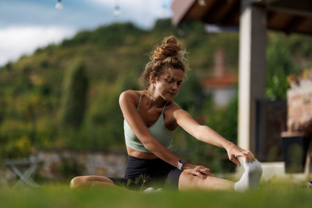 Woman stretching outdoors in a beautiful garden during a sunny day enjoying fitness and tranquility