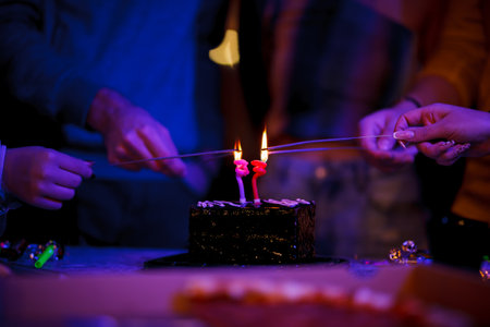 People Lighting Birthday Candles on a Cake During a Celebrationの写真素材