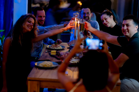 Group of smiling friends toasting at a celebratory dinnerの写真素材