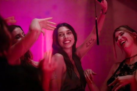 Happy friends celebrating together at a festive party with joyful expressionsの写真素材