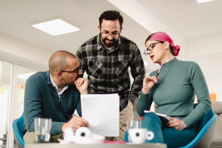 Businesspeople discussing project details in a modern office space during a vibrant brainstorming...