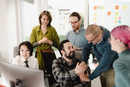 Team collaboration in a modern office as businesspeople engage in discussion and celebrate achievements during a brainstorming session in the afternoonの写真素材