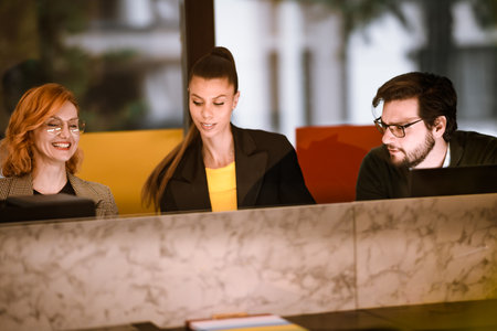 Professionals engaged in a collaborative discussion at a modern workspace in a vibrant city setting during daylight hoursの写真素材