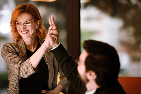 Friends enjoying a playful moment during a fun game at a modern cafe in the afternoon, demonstrating laughter and good camaraderieの写真素材