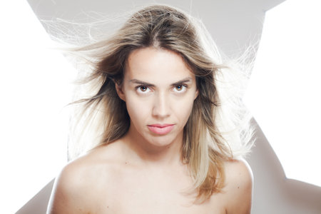 Portrait of a young woman with windswept hair and confident gazeの写真素材