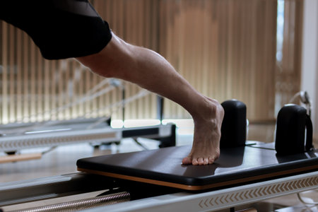Engaging workout on reformer pilates machines in a bright studio focusing on core strength and...