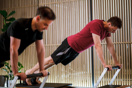 Intense workout session on reformer pilates machines focusing on strength and flexibility in a modern fitness studioの写真素材