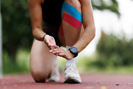 Athlete Preparing for a Sprint Start on a Track Outdoors With Knee Support