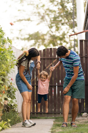Happy family playing outdoors with their child enjoying quality time togetherの写真素材