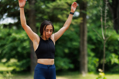 Woman Engaged in Outdoor Exercise Wearing Sporty Attire in a Natural Park Settingの写真素材