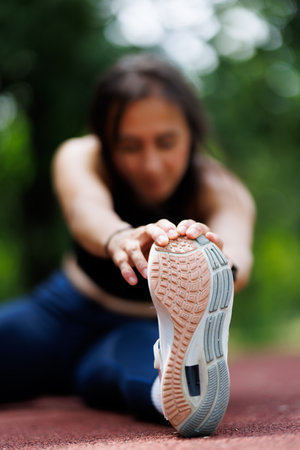 Athlete stretching outdoors on a sunny day focusing on physical activity and fitnessの写真素材