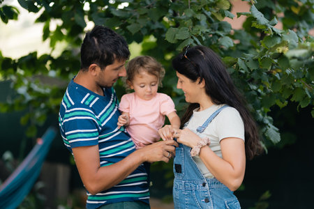 Parents Spending Quality Time Outdoors With Their Young Daughter on a Sunny Day