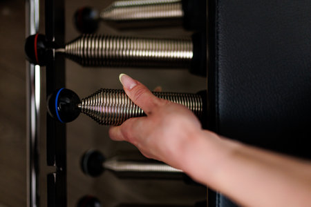 Hand adjusting weight settings on a fitness machine in a modern gym during a workout session
