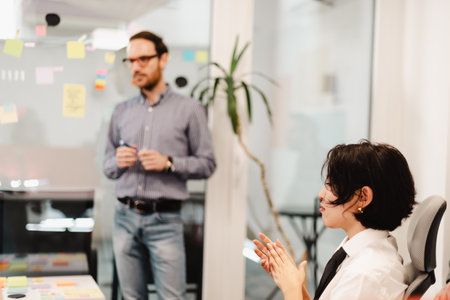 Business meeting in a modern office with professionals reviewing project ideas and providing feedbackの写真素材