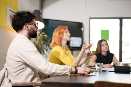 Business meeting with professionals discussing strategies in a bright office environment during the afternoonの写真素材