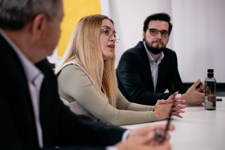 Business professionals engaged in a modern workplace discussionの写真素材