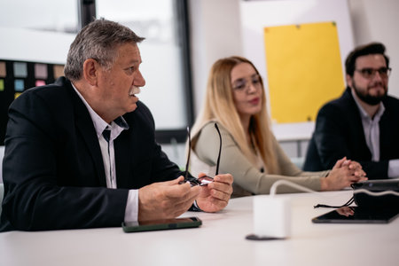 Business team engaged in a collaborative meeting discussing ideas around a conference table in a...