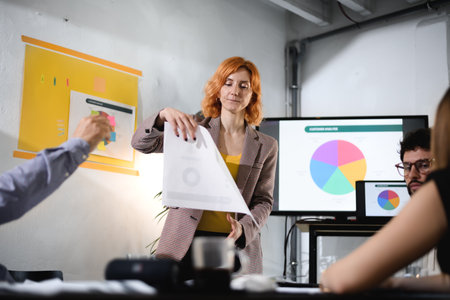 Business meeting with professional presenting data projected on screen, engaged participants in a modern office environmentの写真素材