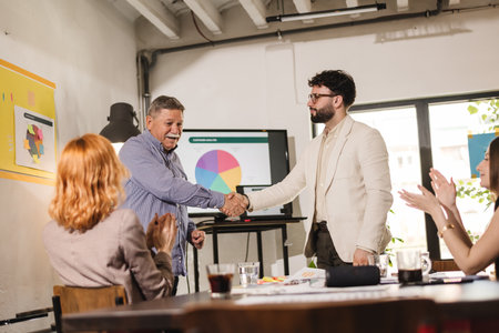 Businessmen shake hands after a successful presentation in a modern office environment during a day...