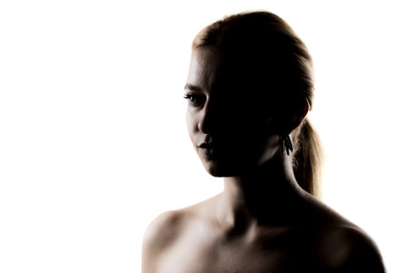 Elegant silhouette of a young woman, artistic portrait with a white backgroundの写真素材