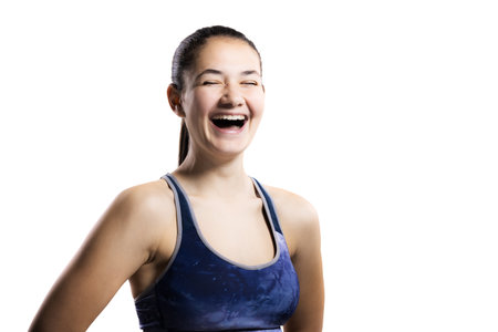 Young female athlete laughing in a workout outfit, isolated on whiteの写真素材