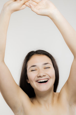 Young woman laughing in a candid portrait, closeup on a white backgroundの写真素材