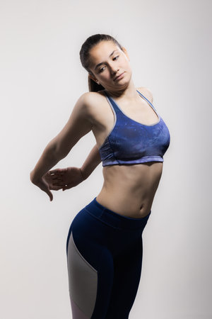 Young female athlete in sports outfit poses with confidence, capturing the essence of strength and determinationの写真素材