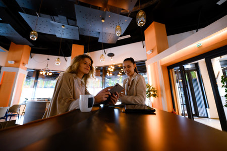Businesswoman engages in discussion with colleague during meeting at modern cafe in the cityの写真素材