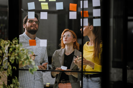Team members brainstorming ideas during a creative meeting in a modern office space with colorful...