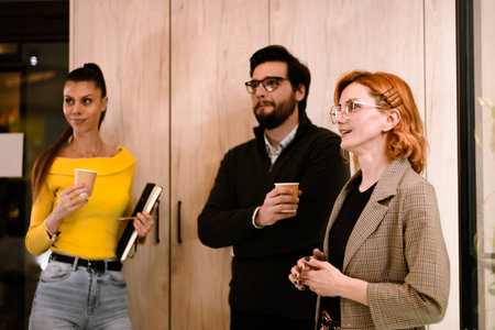 Engaging conversation among three colleagues in a modern office setting during a professional...