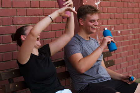Players celebrating after a game, enjoying their time with drinks at a brick wall backdrop in a...