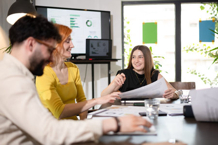 Business meeting with professionals discussing project plans and analyzing charts in a modern office...