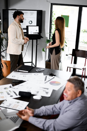 Business meeting in a modern office with professionals engaging in a presentation on project...