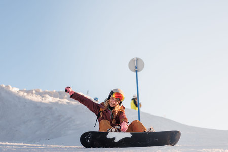 Snowboarder enjoys a sunny day on the slopes while making new friends and practicing skills in a...