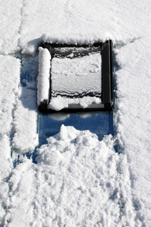 roof window covered of snow on the roof at winterの写真素材