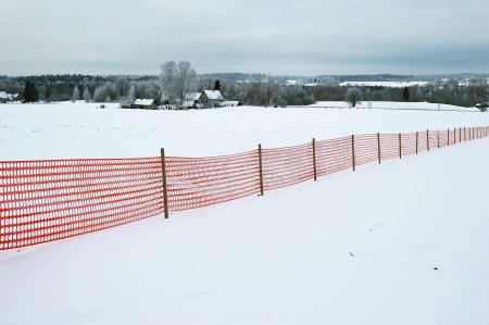 red fence at winter landscapeの写真素材