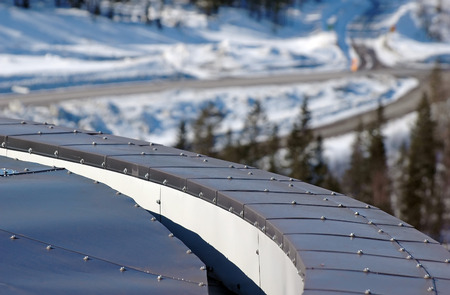 rounded tin roof with screws at winter