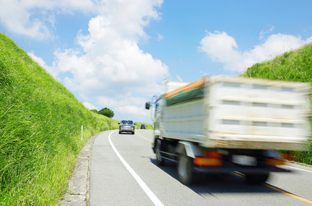 the lorry driving on the country road in Japanの写真素材