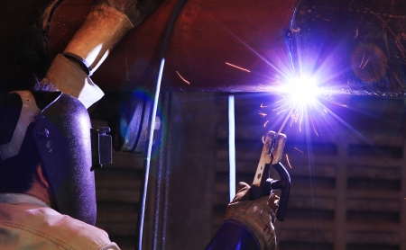 Industrial worker make a spark welding, working place background.の写真素材